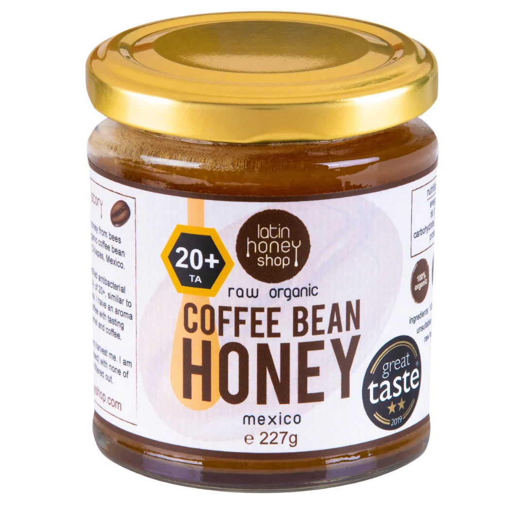 Jar of coffee bean honey with a gold lid on a white background