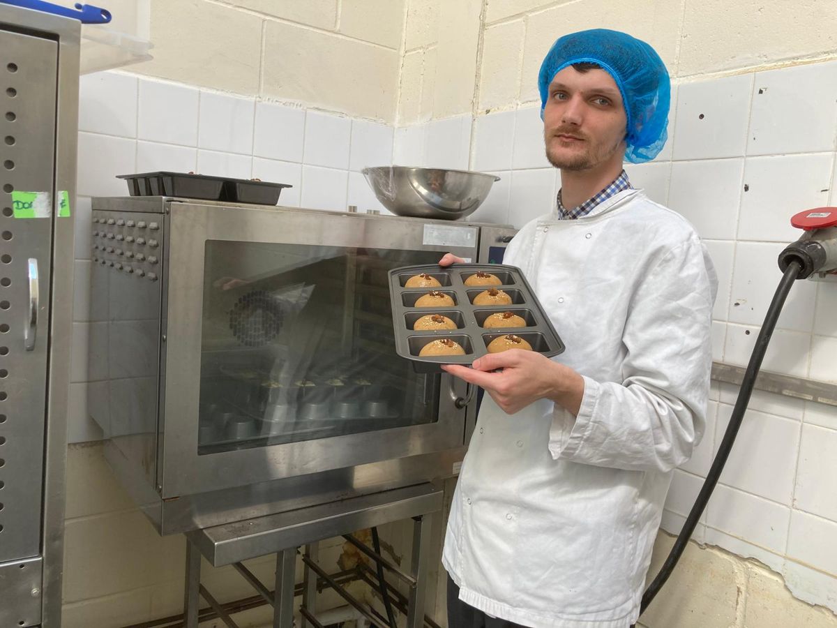 Baker taking a tray of bakes out of the oven during product trials