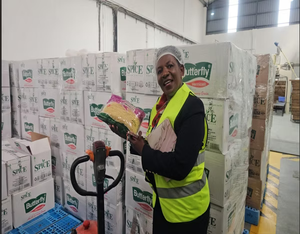 Warehouse worker with palletised boxes of product ready for distribution
