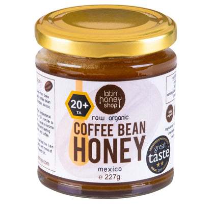 Jar of coffee bean honey with a gold lid on a white background